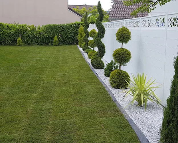 Jardin bien entretenu avec pelouse, allée de gravier blanc, haies et arbres taillés à Allainville près d'Ablis dans les Yvelines 78