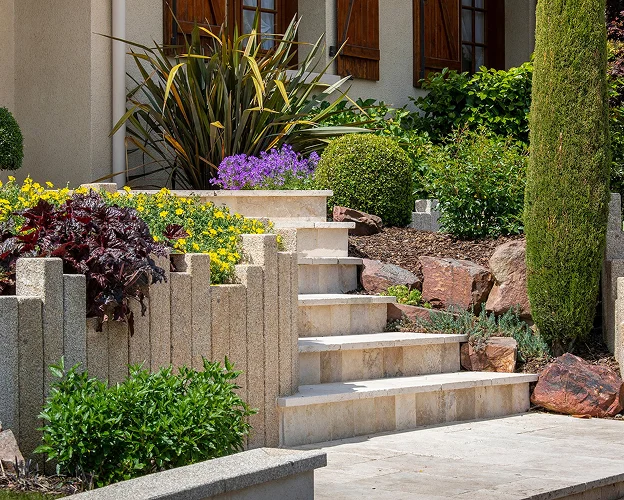 Jardin paysager avec escalier en pierre, fleurs violettes et jaunes, et verdure luxuriante à Allainville près d'Ablis dans les Yvelines 78